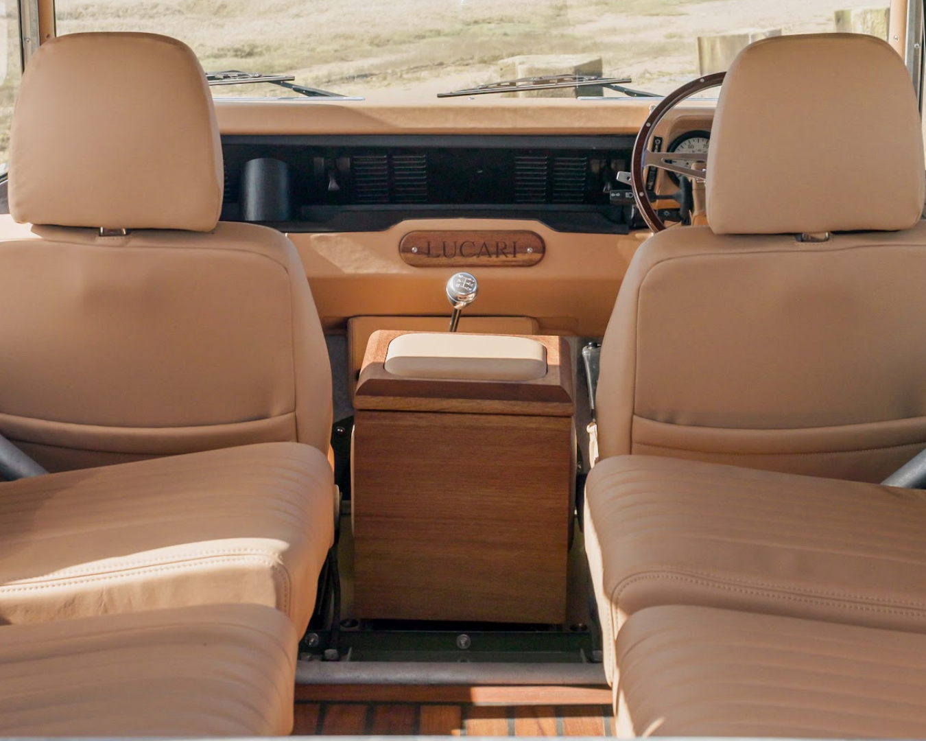 Defender front cabin with LUCARI Barley leather seats, Iroko cubby box and engraved LUCARI dashboard badge