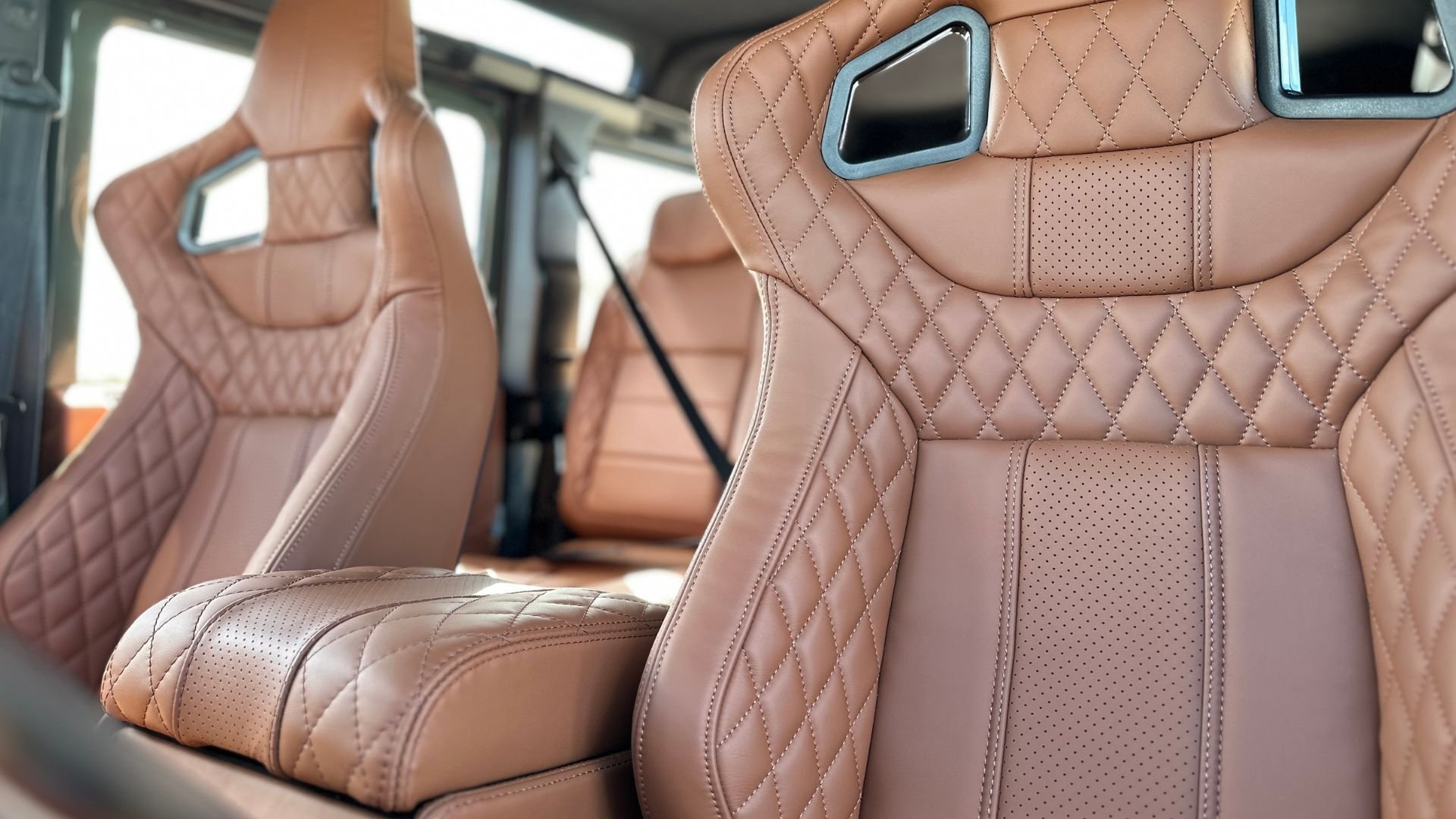 Interior view showing LUCARI Tan leather bucket seats with diamond-stitch quilting and perforated detailing.