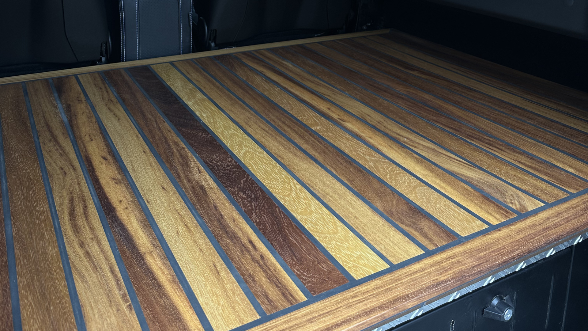 Iroko wood deck flooring in a Defender load area, showing natural grain variation across the boards