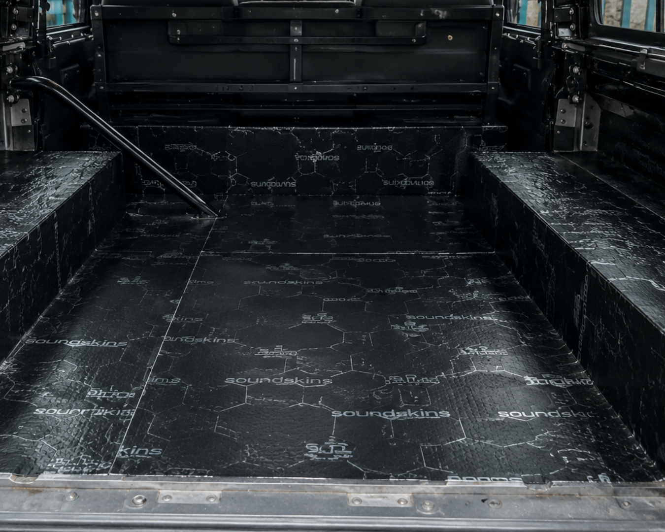 Sound proofing material laid in the full rear floor and wheel arch tops of a stripped-out Land Rover Defender during a LUCARI build