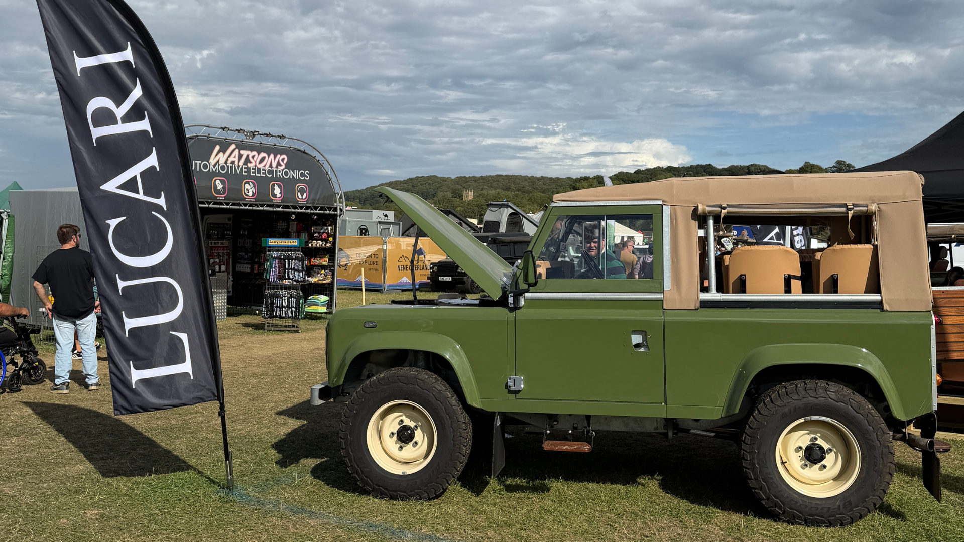 Lincoln Green Defender 90 pickup with bonnet up and Stayfast soft top fitted, parked at the LUCARI stand at the LRO Show.